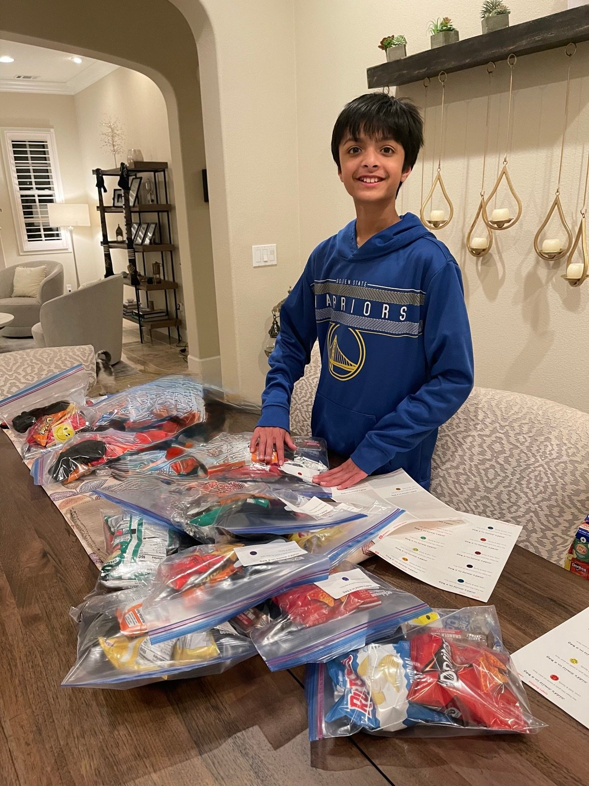 Sidd packing Smile Bags with snacks at the table