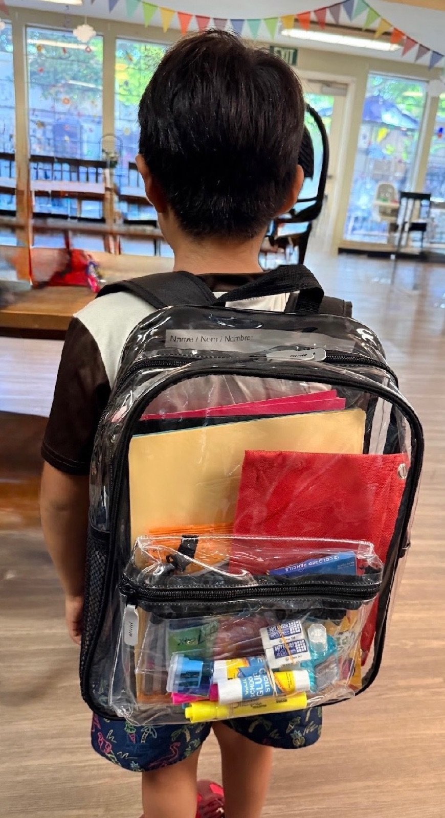 A child wearing a backpack packed with school supplies